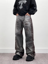 A knife-shaped blood-stained scratch mark on a pair of denim jeans