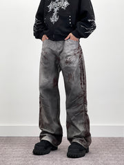 A knife-shaped blood-stained scratch mark on a pair of denim jeans